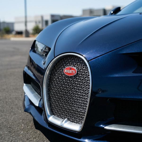 Close-up shot of Bugatti emblem, symbolizing luxury automotive craftsmanship.
