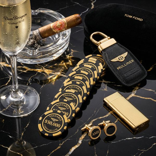 Casino chips with Bentley key and Cartier lighter on marble