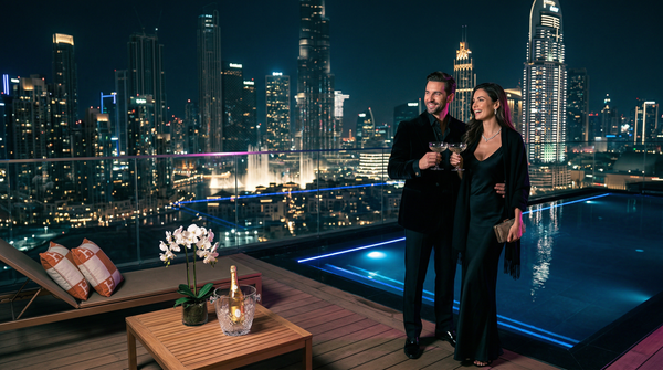Night infinity pool with glamorous couple and Dubai skyline