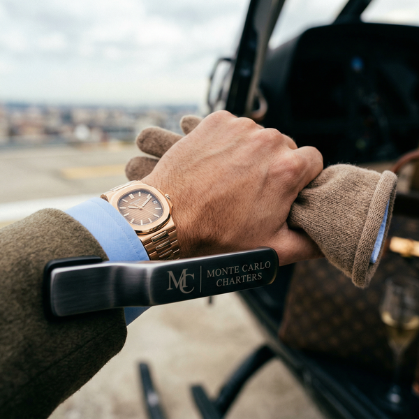 Patek Philippe wrist close-up holding helicopter door handle