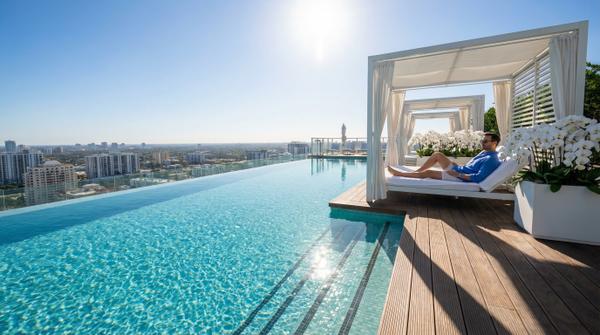 Rooftop pool at noon with stunning views and upscale relaxation