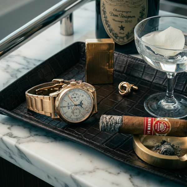 Patek watch and cigar on Calacatta marble yacht bar