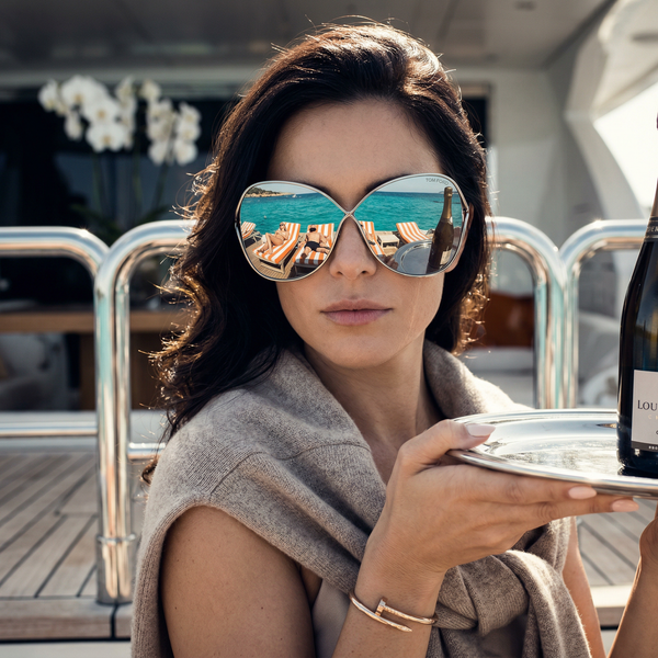 Close-up sunglasses reflection showing Ibiza sea and Cristal