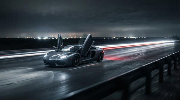 Night highway cruise featuring a sleek Lamborghini Aventador
