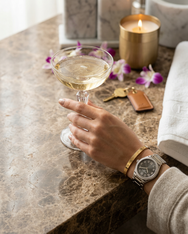 Close-up manicured hand with Patek and Cristal coupe on marble
