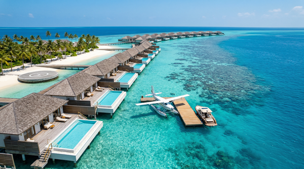 Aerial view of private Maldives island with overwater villas