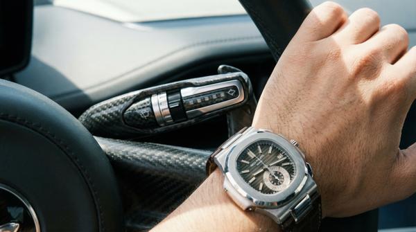 Close-up detail of McLaren 720S with luxury watch, highlighting elegance.
