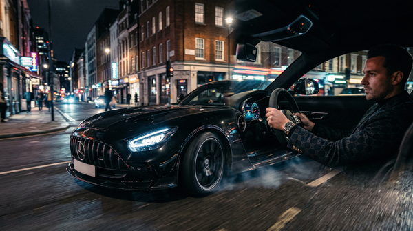 Mercedes-AMG GT night drive with city lights and luxury attire