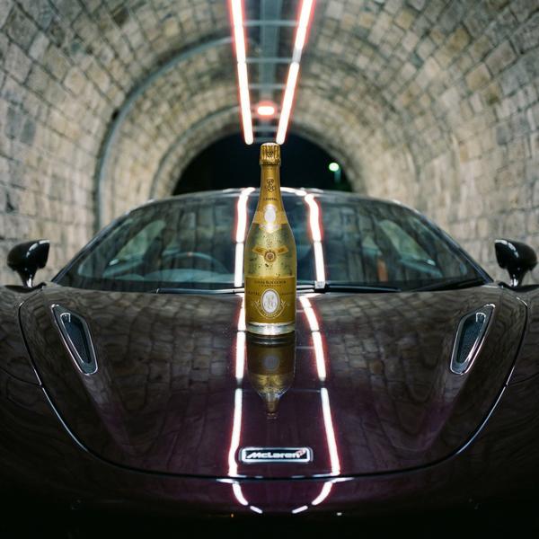 Champagne bottle on luxury car hood in a tunnel setting