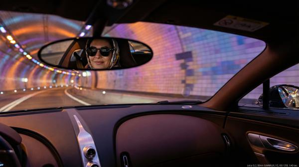 Driver's reflection in tunnel glass with luxury car ambiance