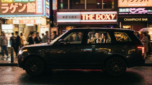 Range Rover amidst vibrant downtown nightlife and luxury vibes