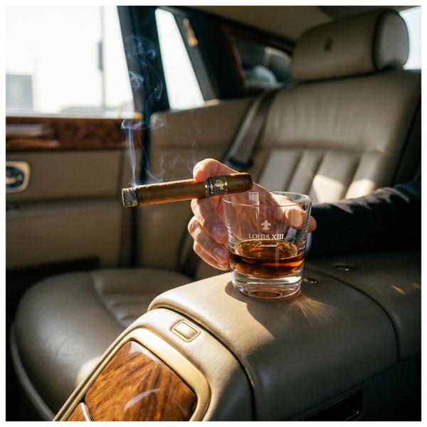 Cigar and cognac inside a luxury Rolls Royce Phantom