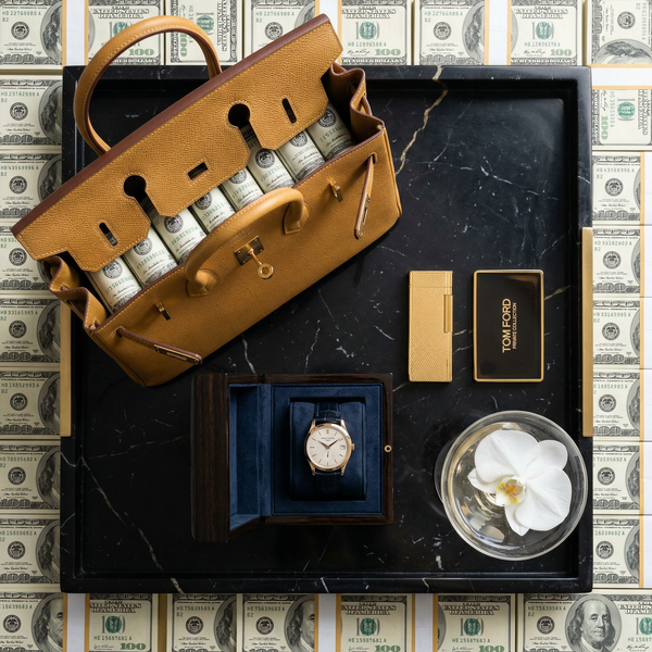 Overhead flatlay Hermès Birkin open with Patek and cash stacks