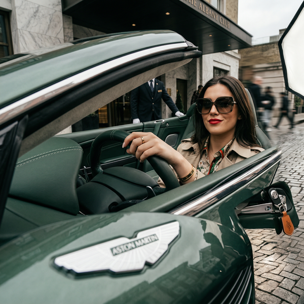 Low-angle luxury car portrait with Cartier bracelet and Aston Martin