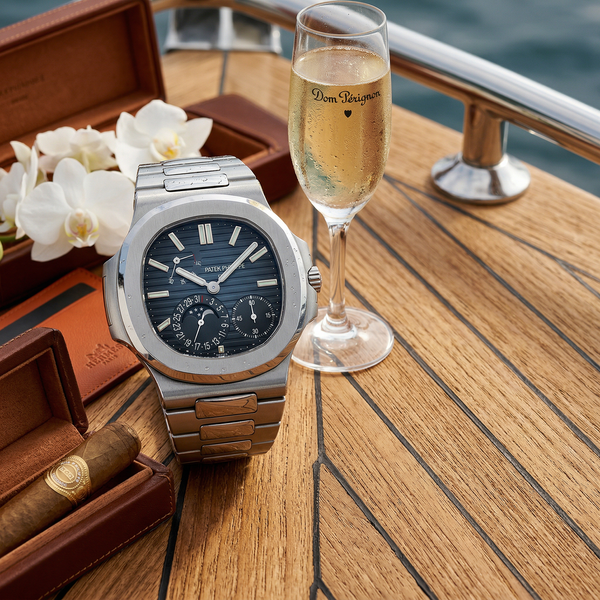 Close-up Patek Nautilus on teak with Dom Pérignon and cigar